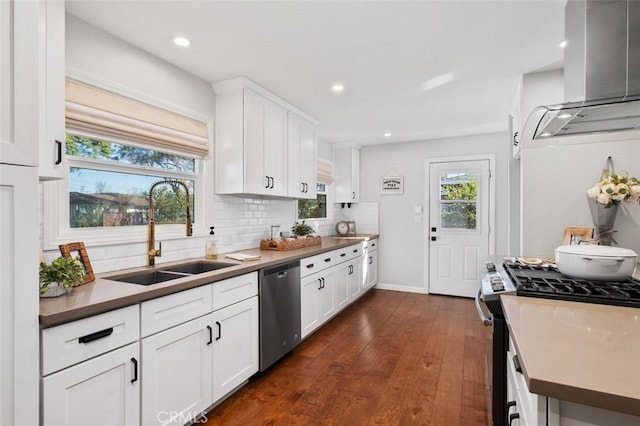 kitchen featuring sink, white cabinetry, backsplash, wall chimney range hood, and appliances with stainless steel finishes