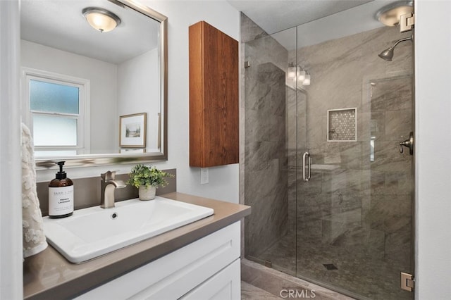 bathroom with walk in shower and vanity