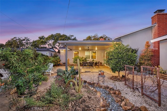 back house at dusk with a patio