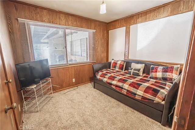 bedroom with wooden walls and light carpet