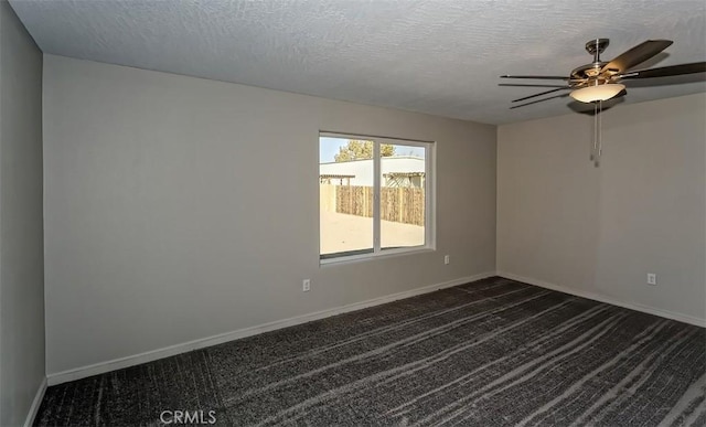 empty room featuring a textured ceiling, ceiling fan, and dark colored carpet