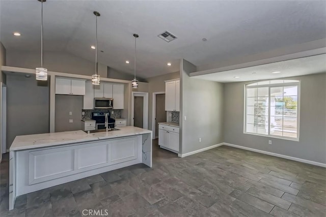 kitchen featuring sink, white cabinets, lofted ceiling, decorative backsplash, and light stone countertops