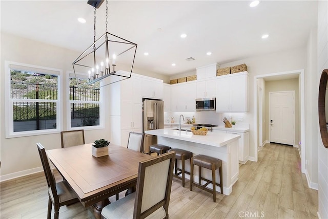 dining space with sink and light hardwood / wood-style floors