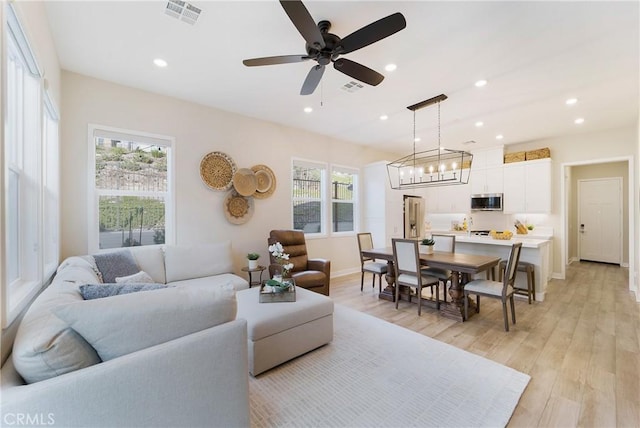 living room with ceiling fan and light wood-type flooring