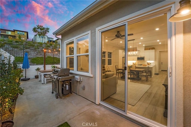 patio terrace at dusk featuring a grill