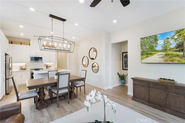 dining space with ceiling fan and light wood-type flooring