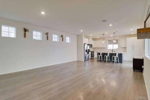 unfurnished living room featuring light hardwood / wood-style flooring and a wealth of natural light