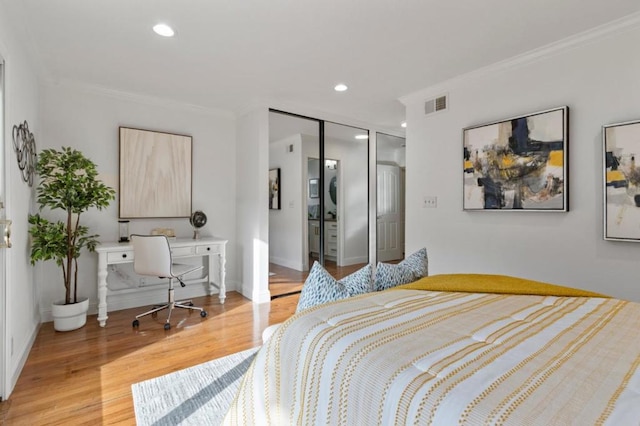 bedroom with crown molding, a closet, and light wood-type flooring