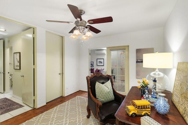 office area featuring ceiling fan, an AC wall unit, and hardwood / wood-style floors