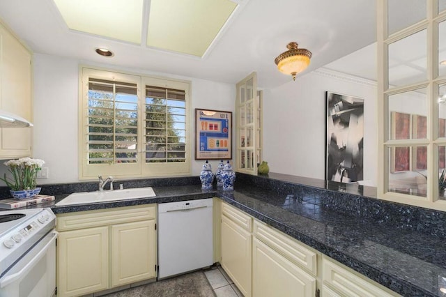 kitchen featuring sink, cream cabinetry, white appliances, and light tile patterned floors