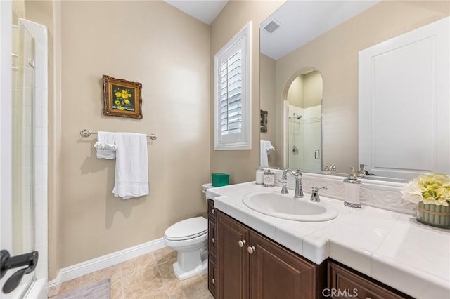 bathroom with toilet, tile patterned flooring, walk in shower, and vanity