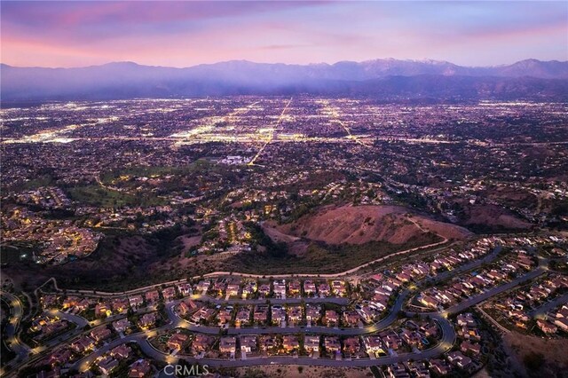 aerial view at dusk featuring a mountain view