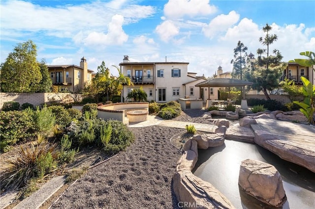 view of yard featuring a balcony, a patio area, and an outdoor fire pit