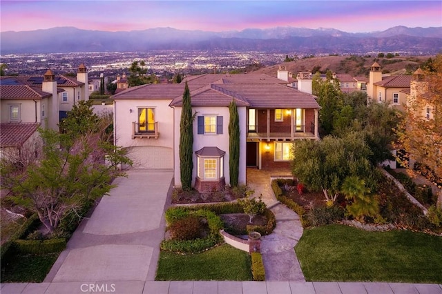 mediterranean / spanish home with a lawn, a garage, and a mountain view