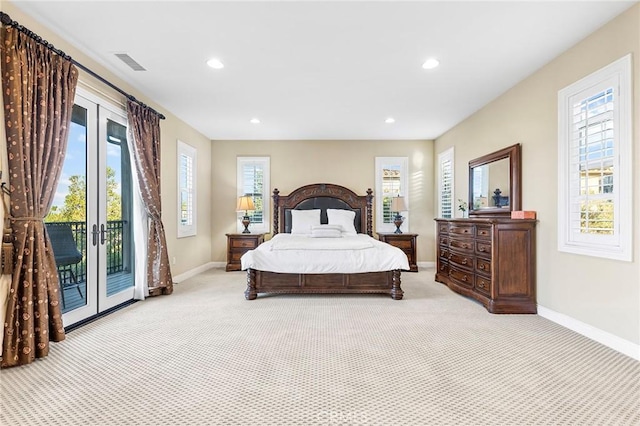 bedroom with multiple windows, light carpet, and access to outside