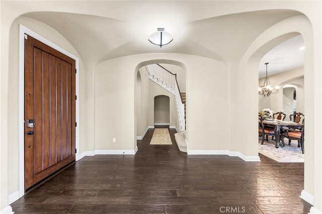 entrance foyer with an inviting chandelier and dark hardwood / wood-style floors