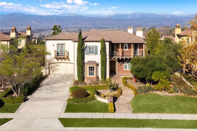 view of front facade with a mountain view, a balcony, and a garage