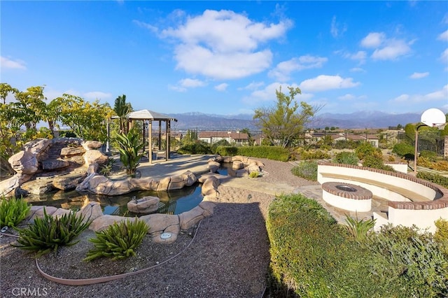 view of yard with an outdoor fire pit, a playground, and a mountain view