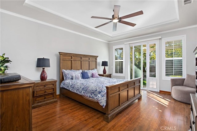 bedroom featuring ceiling fan, a raised ceiling, dark hardwood / wood-style floors, and access to exterior