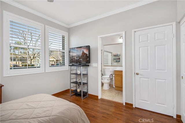 bedroom with ornamental molding, dark hardwood / wood-style floors, and connected bathroom