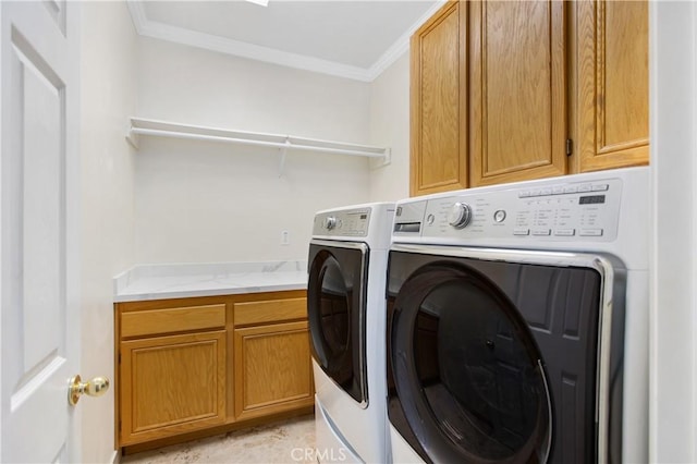 washroom featuring ornamental molding, cabinets, and washing machine and clothes dryer