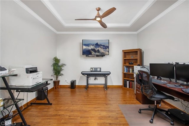 home office with hardwood / wood-style flooring, ceiling fan, a tray ceiling, and ornamental molding