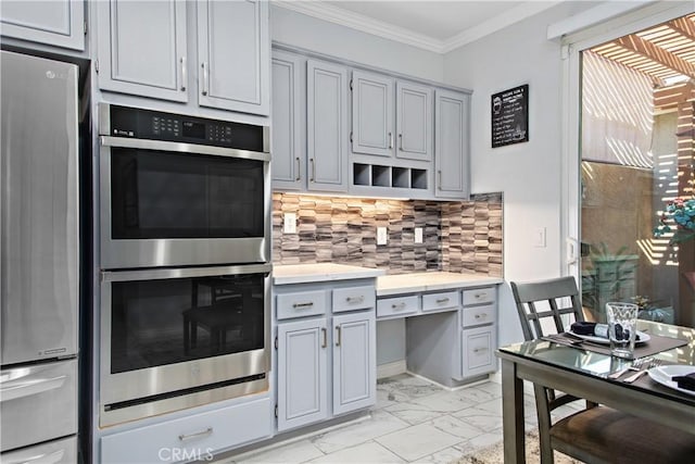 kitchen featuring decorative backsplash, crown molding, gray cabinetry, and appliances with stainless steel finishes