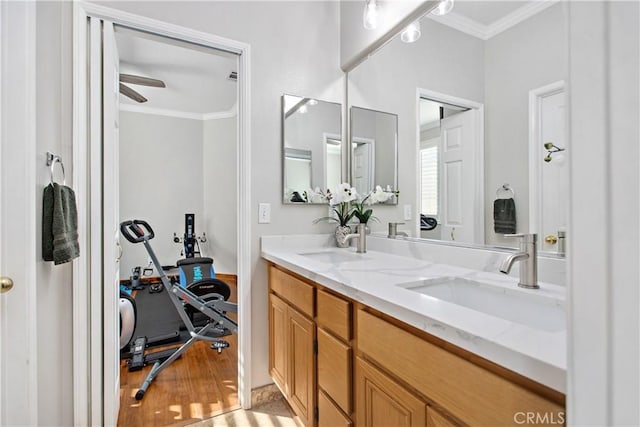 bathroom featuring ceiling fan, ornamental molding, and vanity