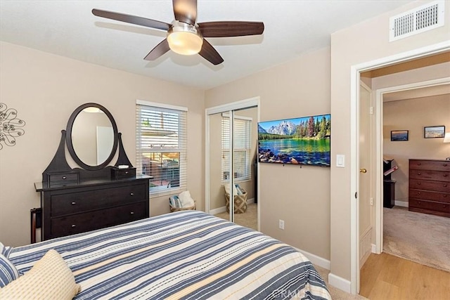 bedroom featuring ceiling fan, a closet, and light hardwood / wood-style flooring