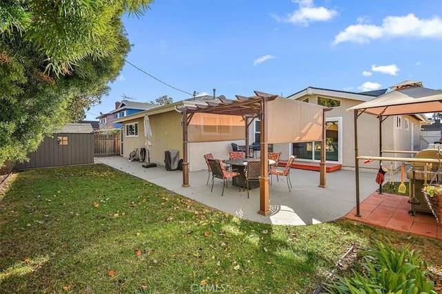 back of property featuring a storage unit, a yard, a pergola, and a patio