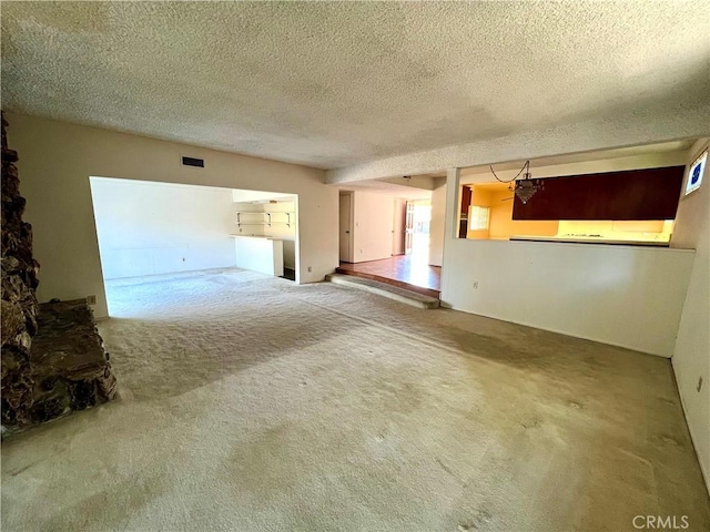 unfurnished living room featuring a textured ceiling and carpet floors