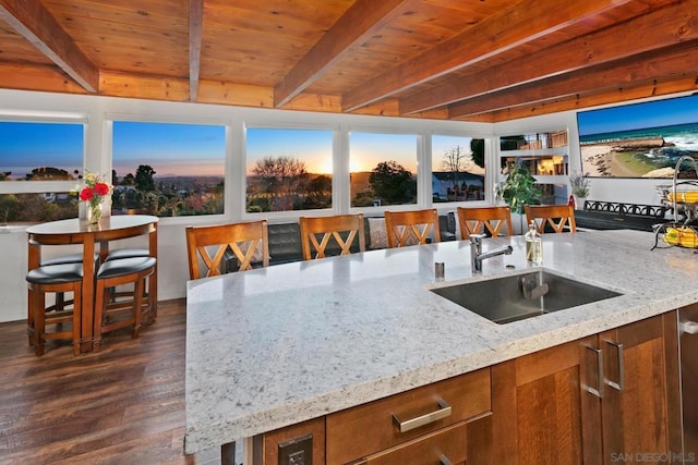 kitchen with wood ceiling, light stone countertops, beamed ceiling, dark hardwood / wood-style flooring, and sink