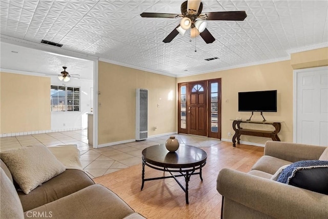 living room with tile patterned flooring, crown molding, and ceiling fan