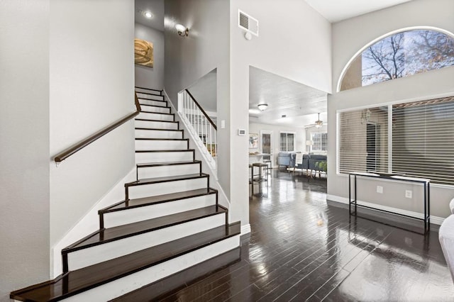 staircase featuring ceiling fan and hardwood / wood-style floors