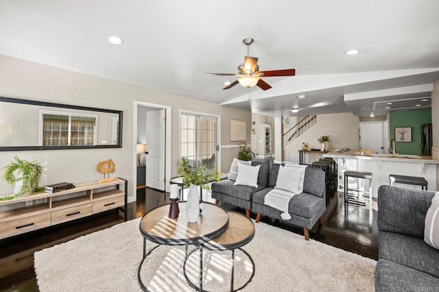 living room featuring lofted ceiling, dark wood-type flooring, and ceiling fan