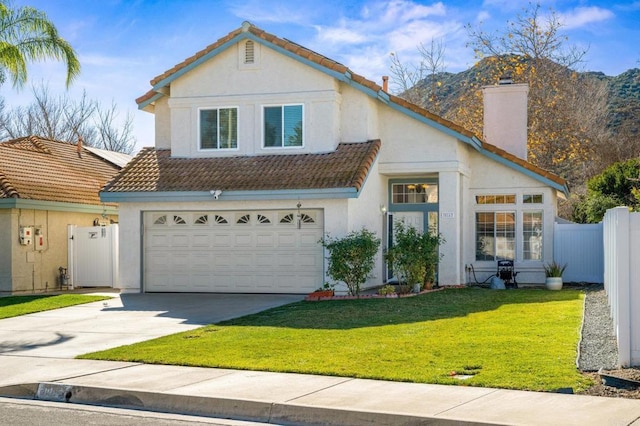 view of property featuring a mountain view, a front lawn, and a garage