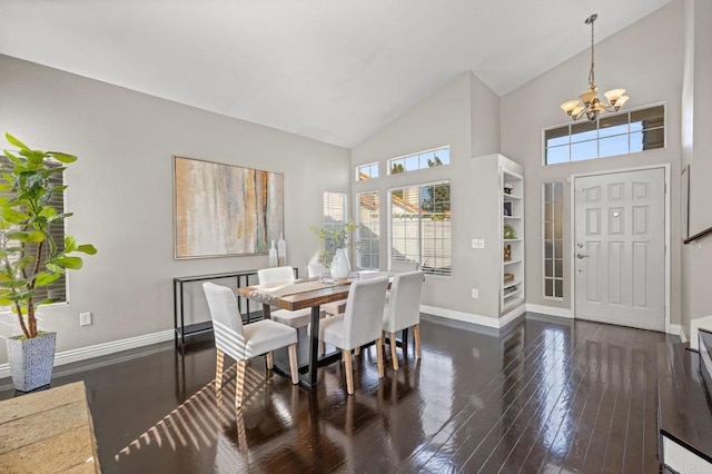 dining space featuring built in shelves, dark hardwood / wood-style flooring, a towering ceiling, and a chandelier