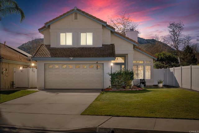 view of front of home with a lawn, a garage, and a mountain view