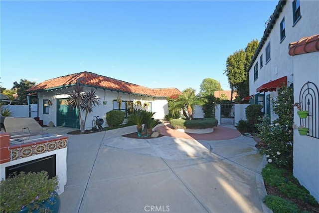 view of front of property featuring a gate, a patio area, stucco siding, and fence