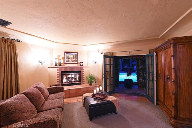 carpeted living area featuring a brick fireplace, a textured ceiling, and visible vents