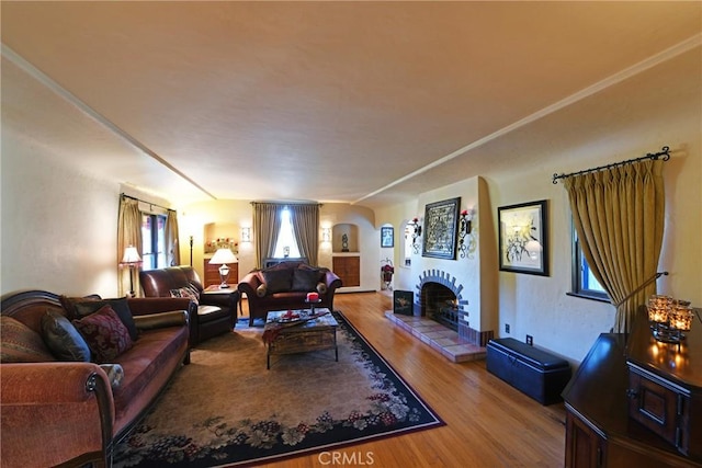 living room featuring wood-type flooring and a tiled fireplace