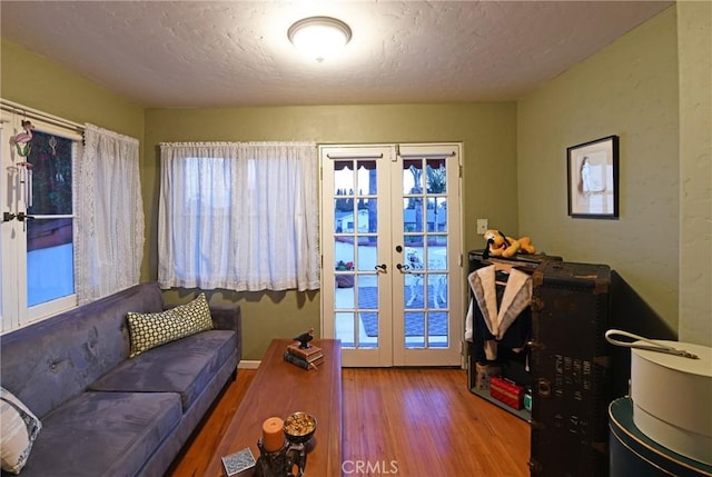 living room with a textured ceiling, french doors, and wood finished floors