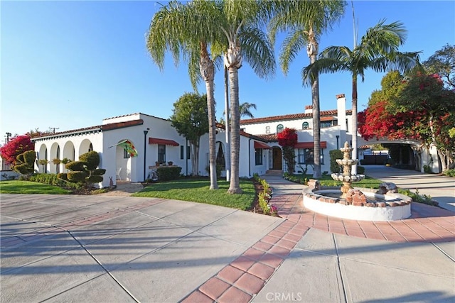 mediterranean / spanish home featuring concrete driveway and stucco siding