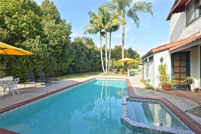view of pool with a patio and a pool with connected hot tub