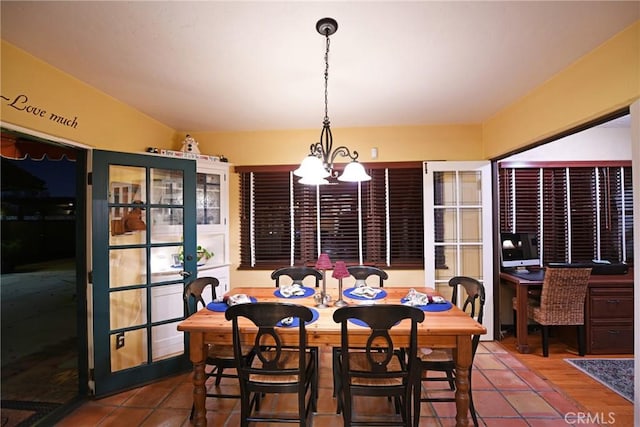 tiled dining room with a chandelier