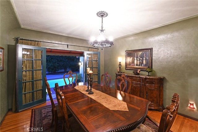 dining space featuring wood finished floors and a chandelier