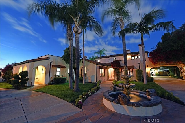 mediterranean / spanish-style house with curved driveway and stucco siding