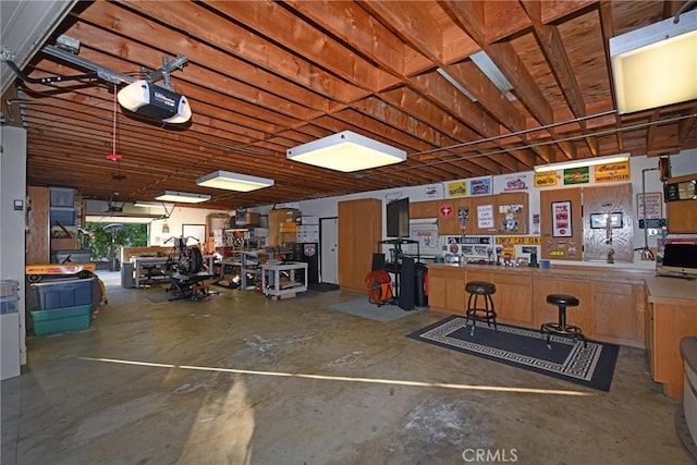 garage with a workshop area and a garage door opener