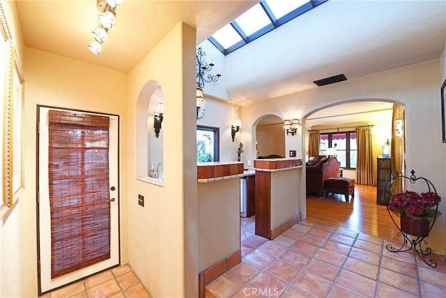 foyer with arched walkways and light tile patterned floors
