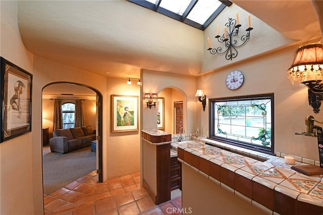 bathroom with a skylight, ensuite bathroom, and a high ceiling